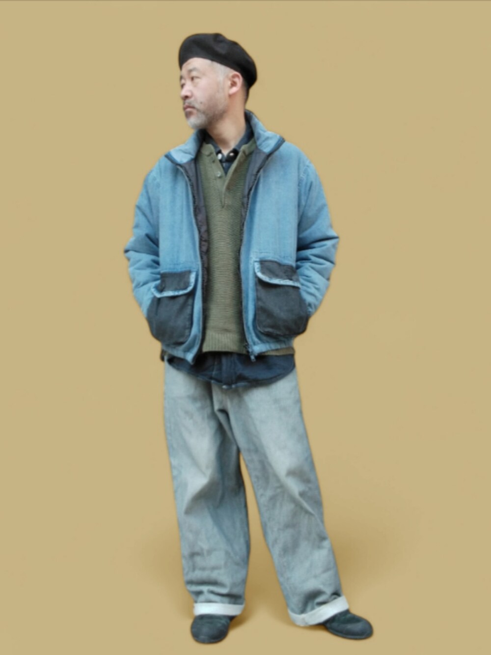 グレー系のデニムパンツ、ブラック系のスニーカー、グリーン系のニット/セーターを着用したメンズの秋コーディネートの4枚目の写真