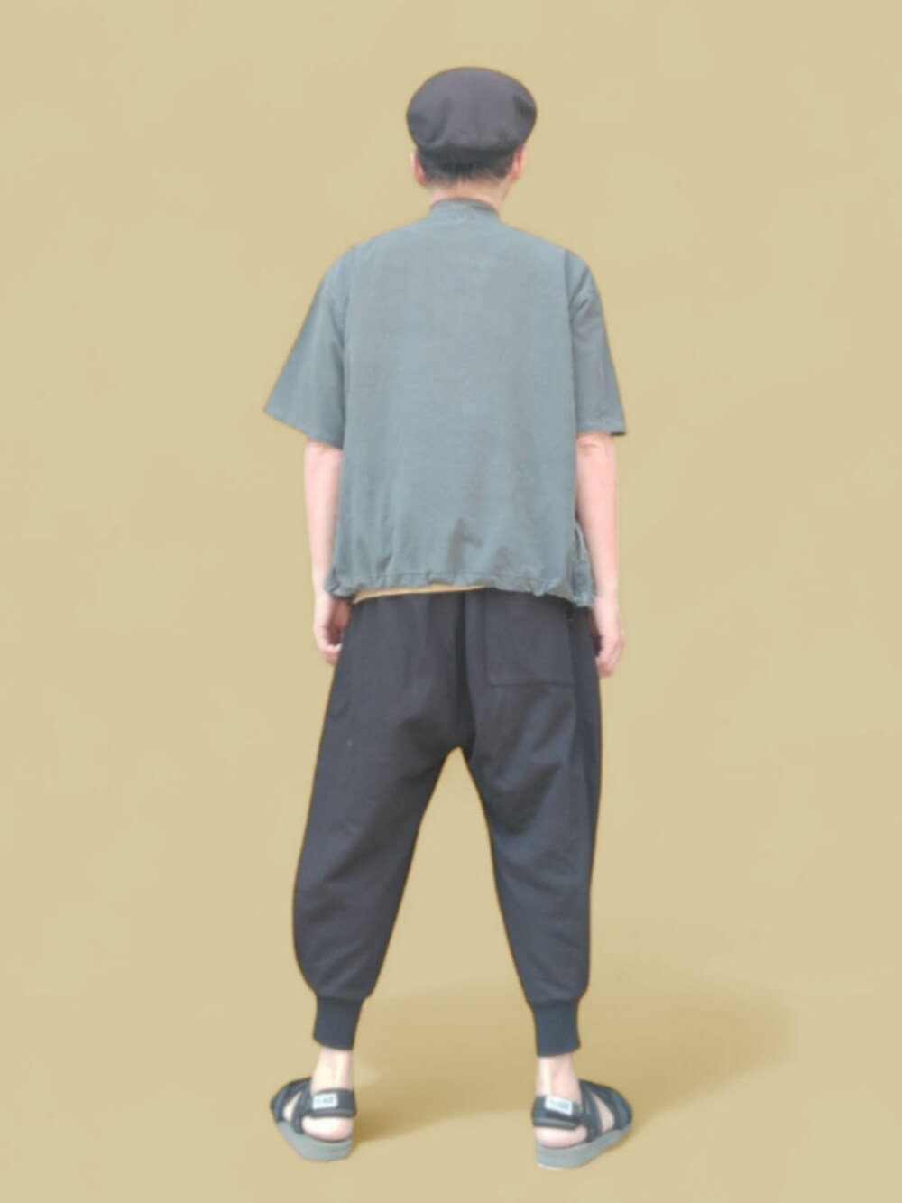 グレー系のパンツ、グリーン系のサンダル、イエロー系のニット/セーターを着用したメンズの春コーディネートの5枚目の写真