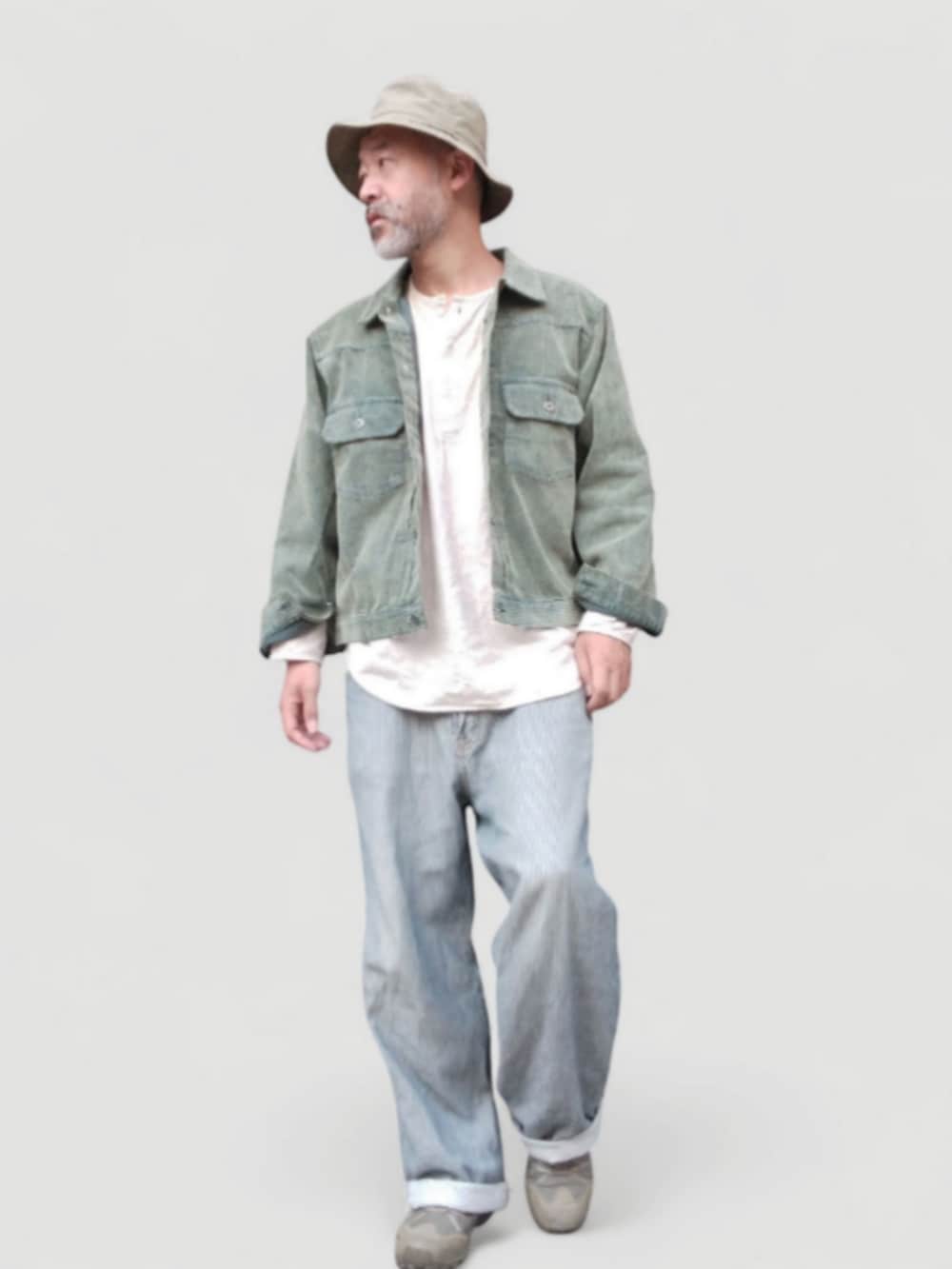 グレー系のデニムパンツ、グリーン系のスニーカー、グリーン系のジャケット/アウターを着用したメンズの秋コーディネートの2枚目の写真