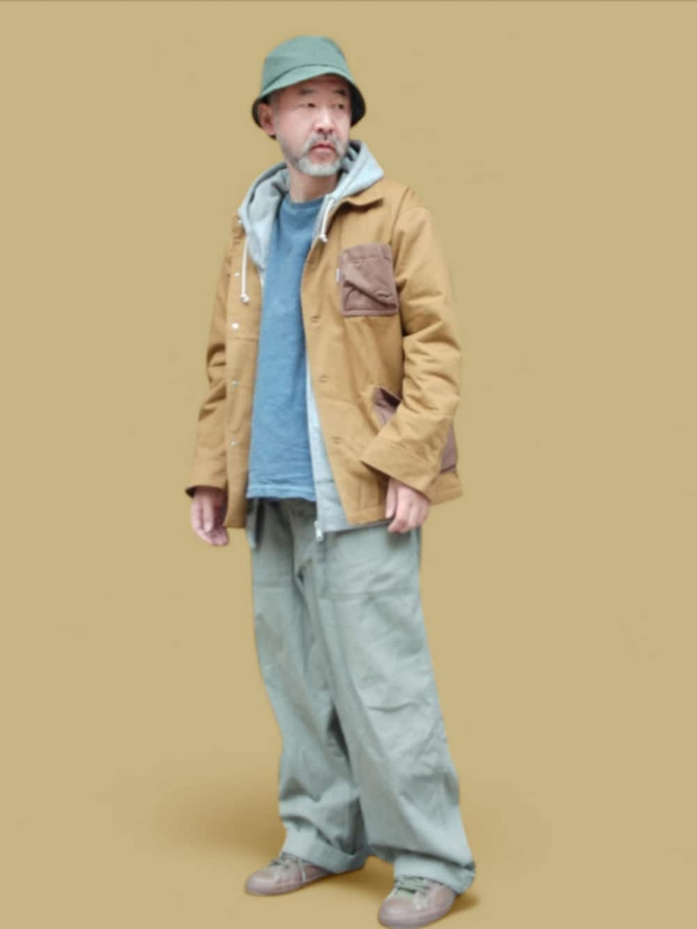 グリーン系のカーゴパンツ、グリーン系のスニーカー、イエロー系のカバーオールを着用したメンズの冬コーディネートの4枚目の写真