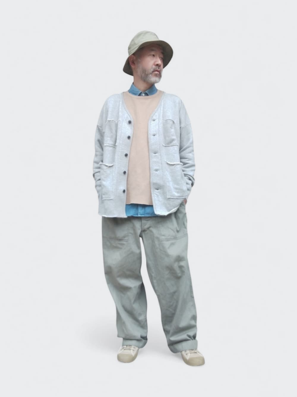 グリーン系のカーゴパンツ、グレー系のカーディガン/ボレロ、ベージュ系のスウェットを着用したメンズの春コーディネートの2枚目の写真