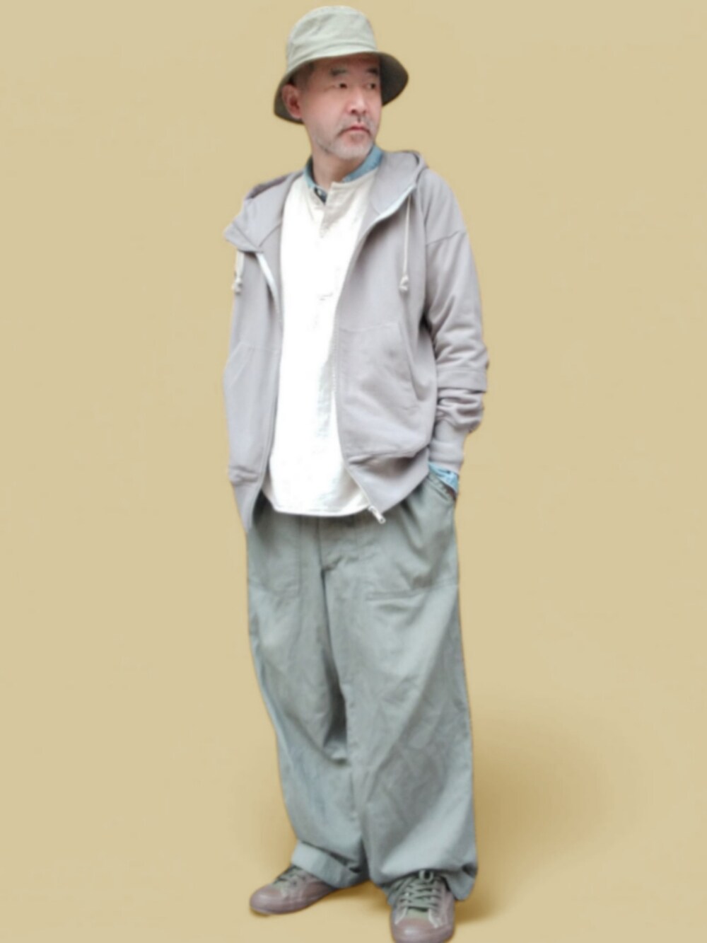 グリーン系のカーゴパンツ、ホワイト系のTシャツ/カットソー、グレー系のパーカーを着用したメンズの春コーディネートの3枚目の写真