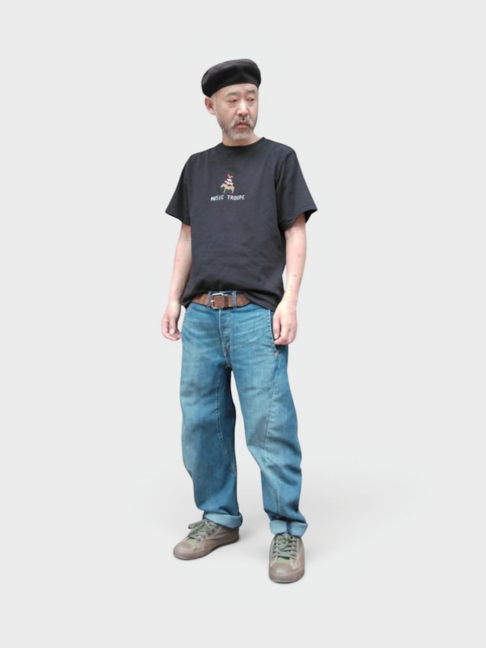 グリーン系のスニーカー、ブルー系のデニムパンツ、ブラック系のTシャツ/カットソーを着用したメンズの夏コーディネートの3枚目の写真