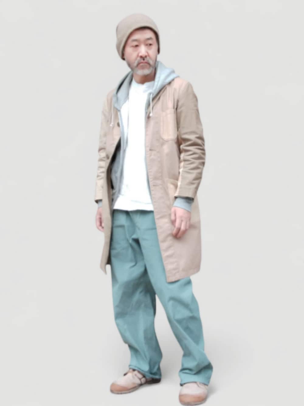 グリーン系のパンツ、ベージュ系のスニーカー、ベージュ系のステンカラーコートを着用したメンズの冬コーディネートの2枚目の写真