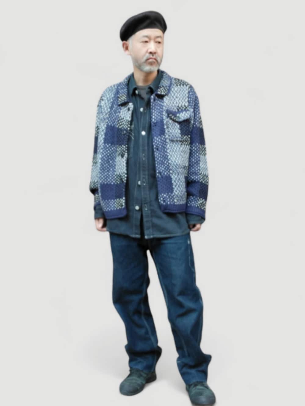 ブラック系のスニーカー、ブルー系のデニムパンツ、ブルー系のニット/セーターを着用したメンズの冬コーディネートの2枚目の写真