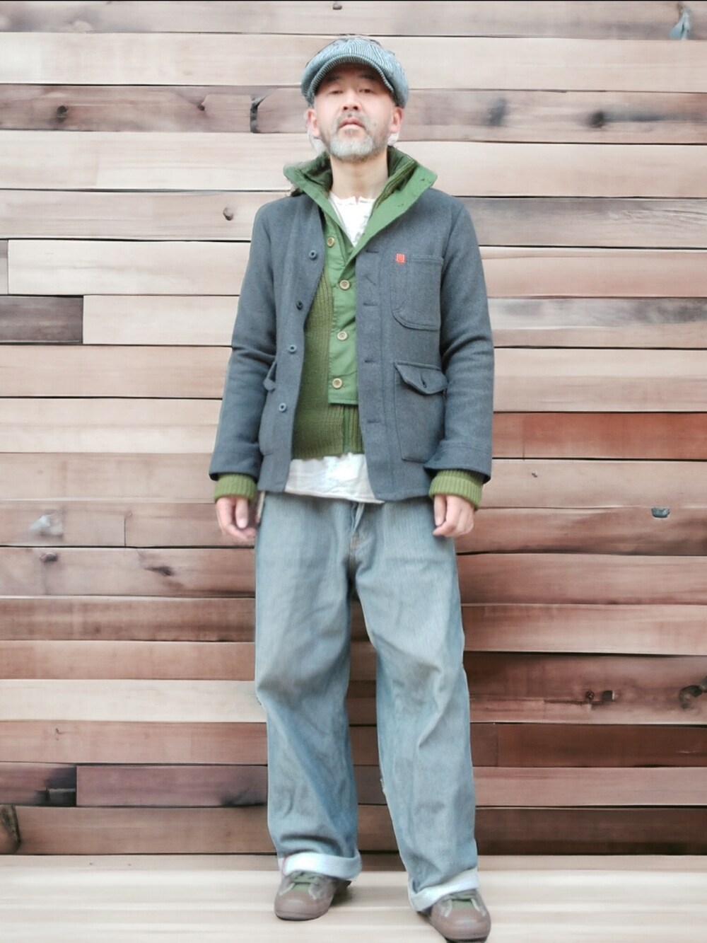 グレー系のデニムパンツ、グリーン系のスニーカー、グレー系のノーカラージャケットを着用したメンズの冬コーディネートの3枚目の写真