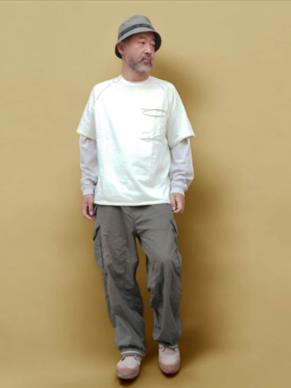 グリーン系のカーゴパンツ、ベージュ系のスニーカー、ホワイト系のTシャツ/カットソーを着用したメンズの夏コーディネートの4枚目の写真