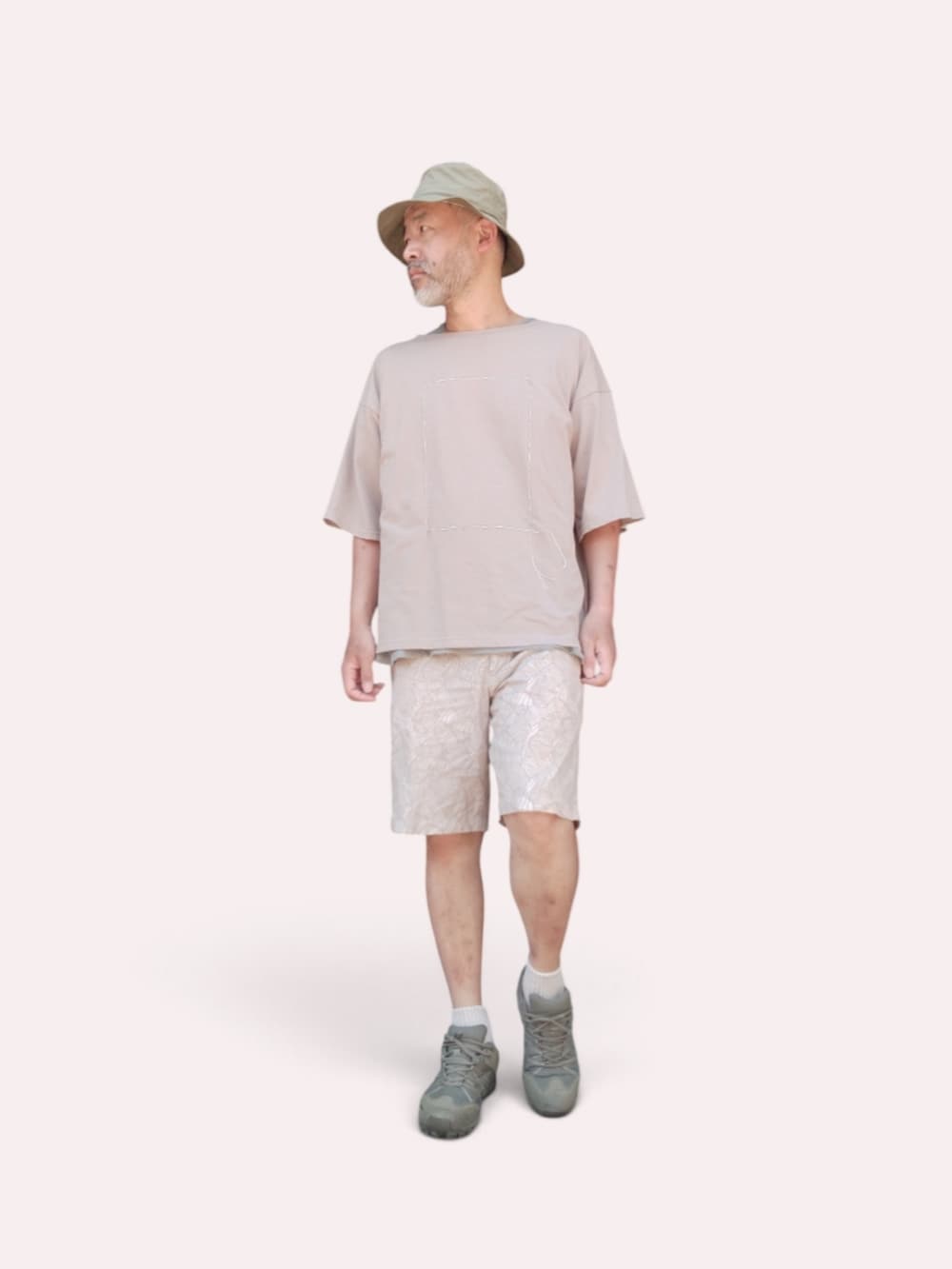ベージュ系のその他パンツ、グリーン系のスニーカー、ベージュ系のTシャツ/カットソーを着用したメンズの夏コーディネートの4枚目の写真