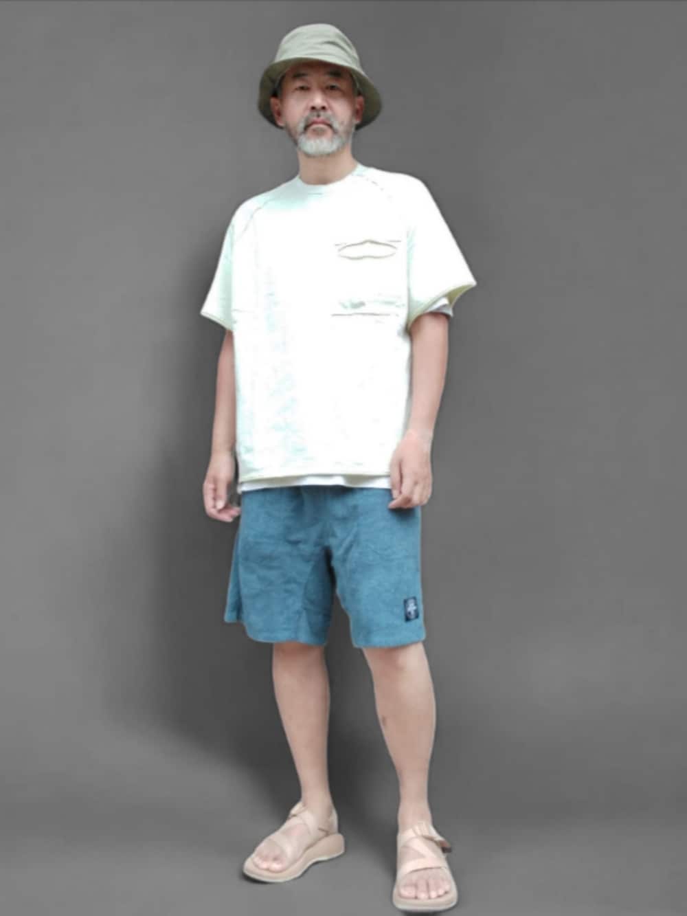 ホワイト系のTシャツ/カットソー、ブルー系のパンツ、ベージュ系のサンダルを着用したメンズの夏コーディネートの2枚目の写真