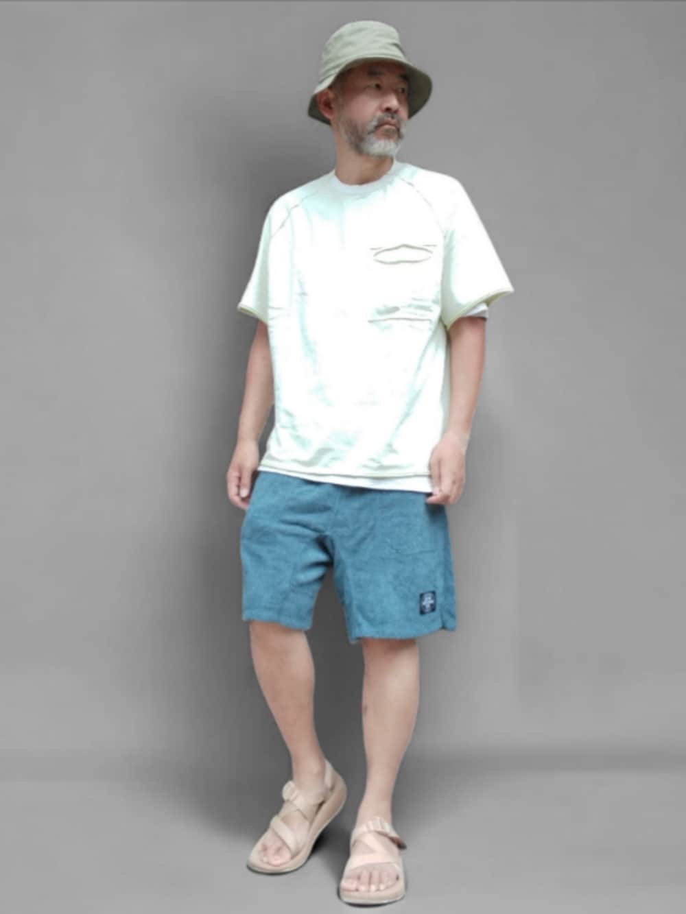 ホワイト系のTシャツ/カットソー、ブルー系のパンツ、ベージュ系のサンダルを着用したメンズの夏コーディネートの4枚目の写真
