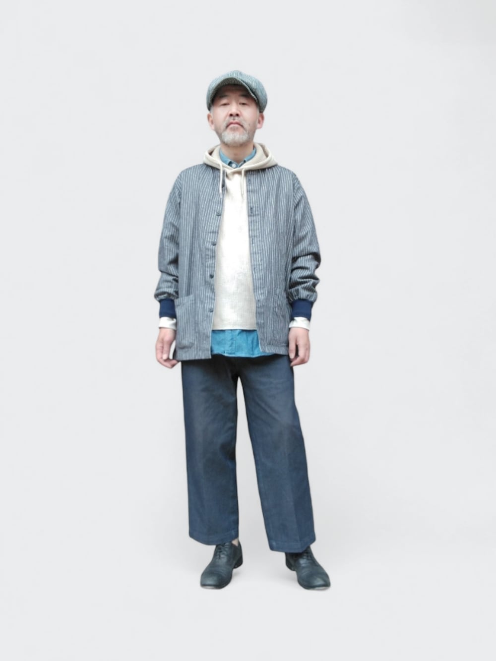 ブルー系のその他パンツ、ベージュ系のパーカー、ブルー系のシャツ/ブラウスを着用したメンズの春コーディネートの2枚目の写真