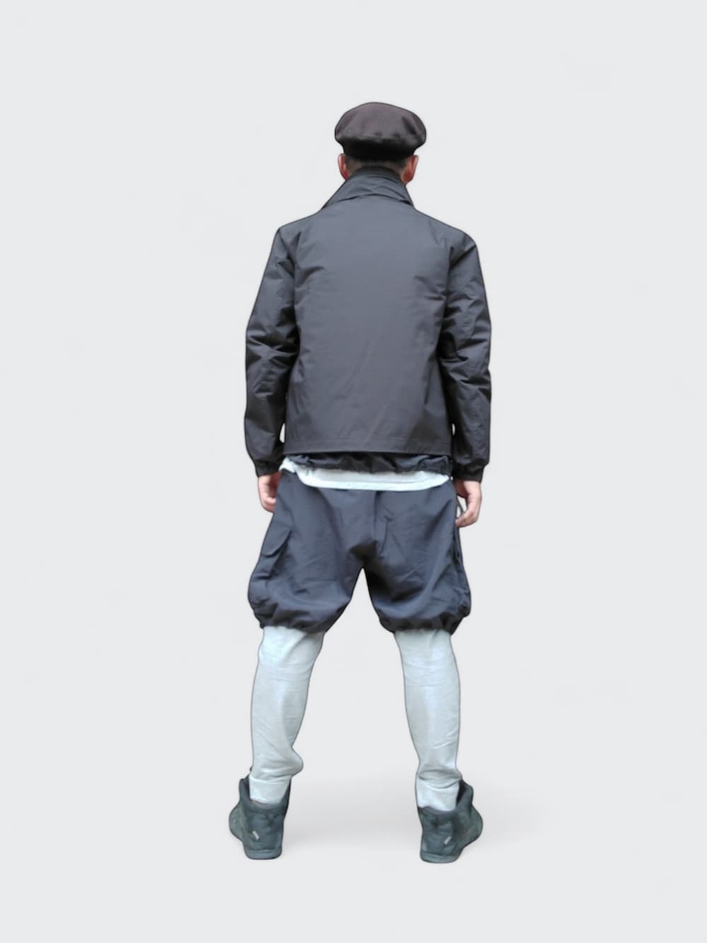 ブラック系のスニーカー、ブラック系のTシャツ/カットソー、ブラック系のダウンジャケット/コートを着用したメンズの冬コーディネートの5枚目の写真