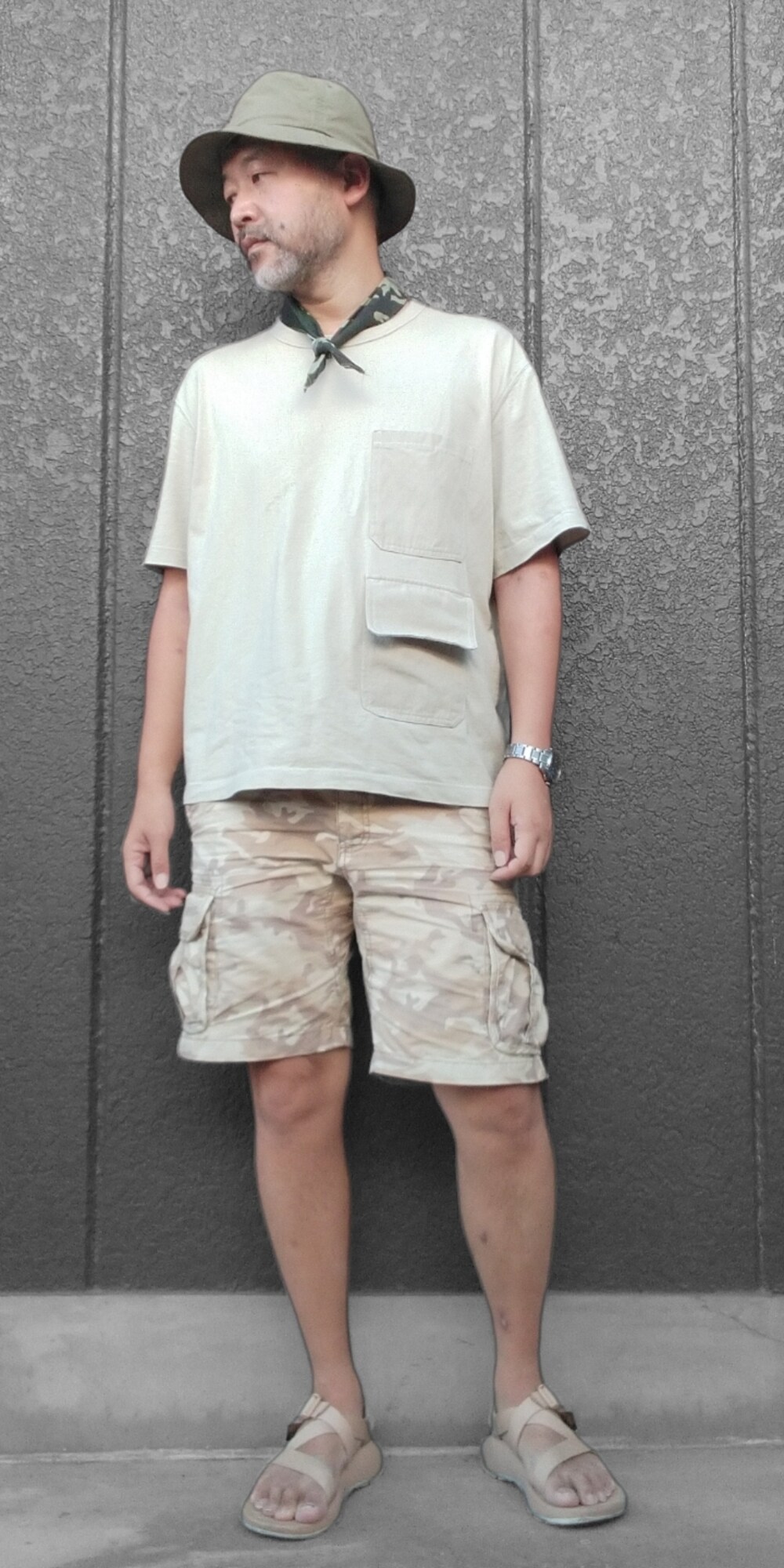 ベージュ系のTシャツ/カットソー、ベージュ系のカーゴパンツ、ベージュ系のサンダルを着用したメンズの夏コーディネートの2枚目の写真