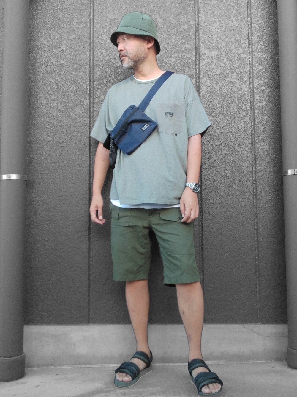 グリーン系のTシャツ/カットソー、ブルー系のボディバッグ/ウエストポーチ、グリーン系のその他パンツを着用したメンズの夏コーディネートの3枚目の写真
