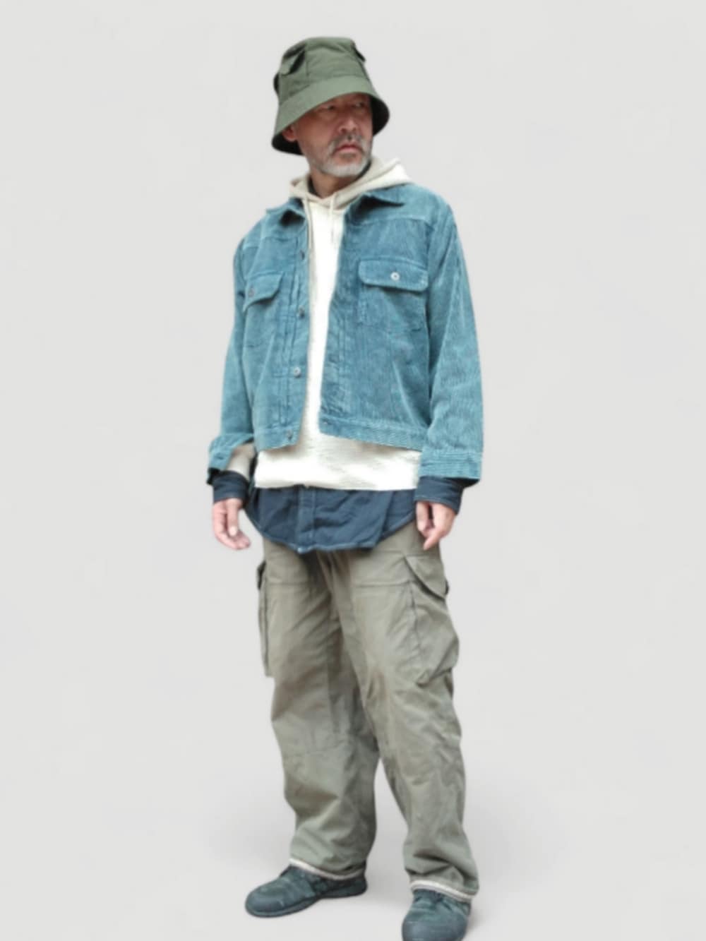 グリーン系のカーゴパンツ、ブラック系のスニーカー、ブルー系のジャケット/アウターを着用したメンズの秋コーディネートの3枚目の写真