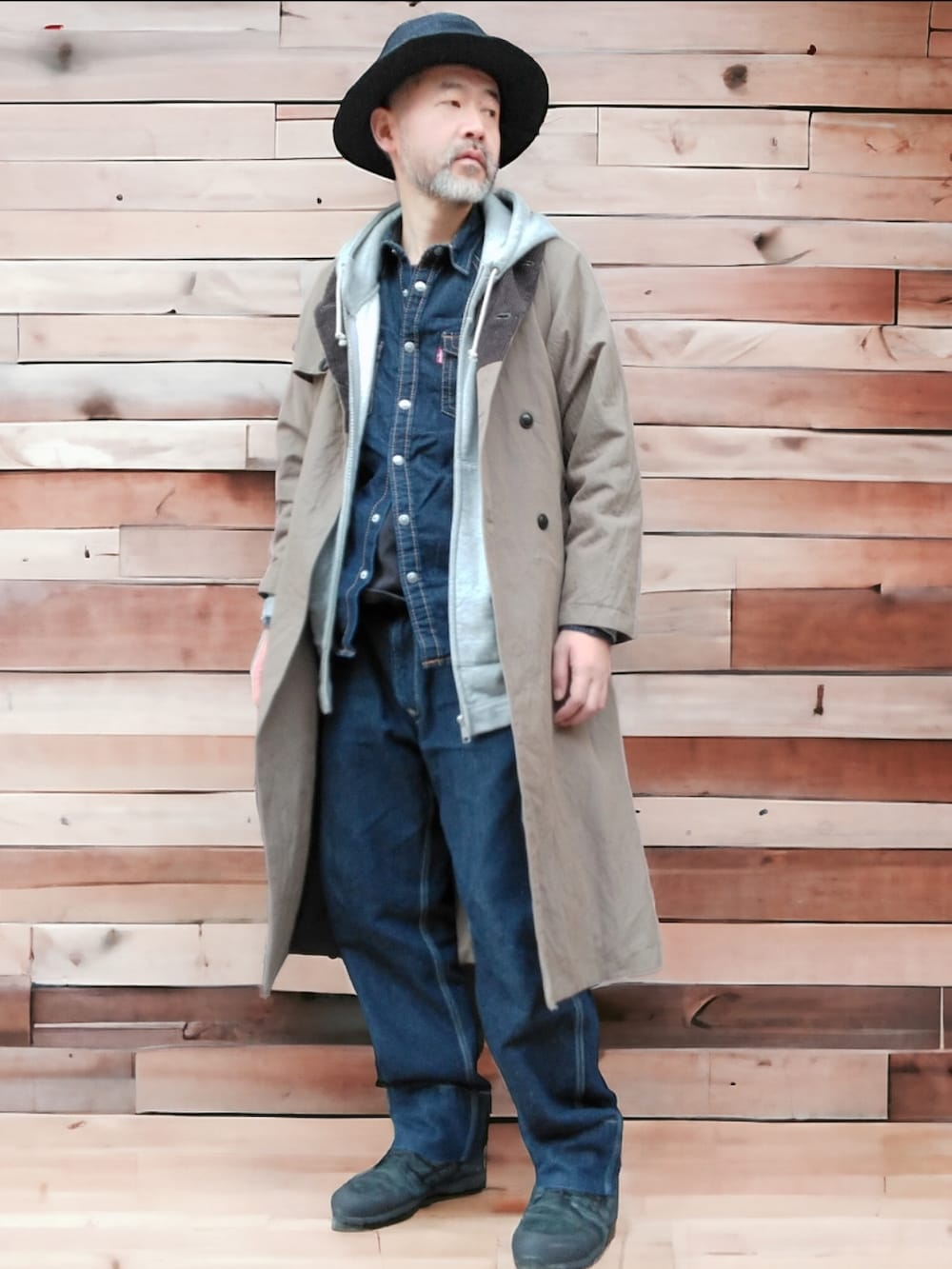 グリーン系のトレンチコート、ブルー系のシャツ/ブラウス、ブルー系のデニムパンツを着用したメンズの冬コーディネートの3枚目の写真