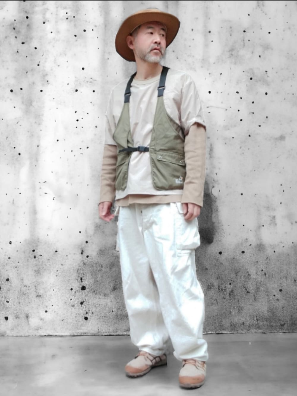 ベージュ系のその他トップス、グリーン系のベスト、ホワイト系のカーゴパンツを着用したメンズの春コーディネートの2枚目の写真