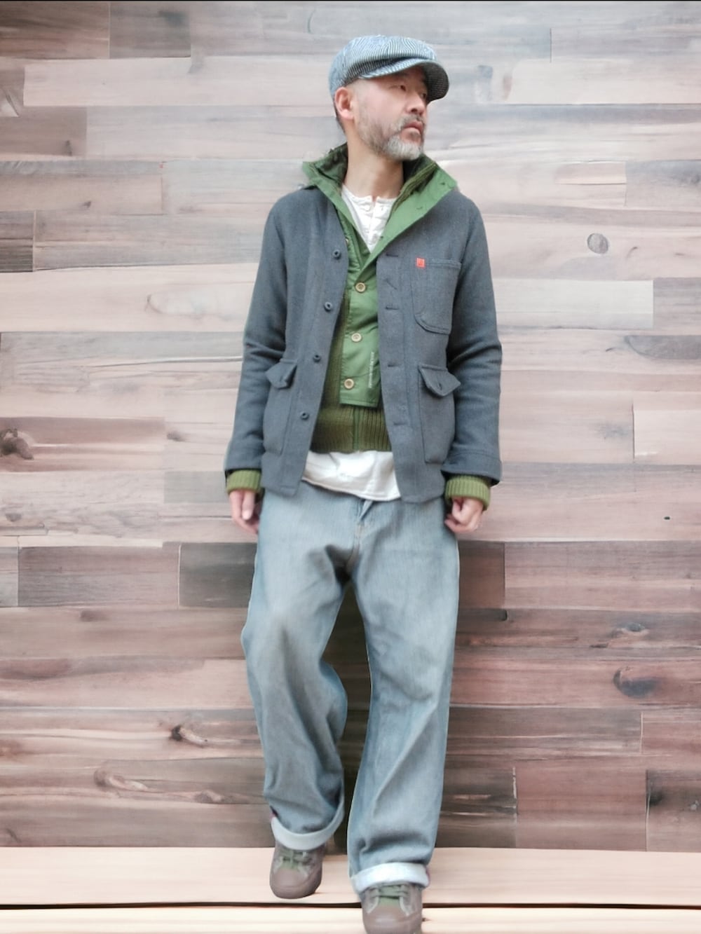 グレー系のデニムパンツ、グリーン系のスニーカー、グレー系のノーカラージャケットを着用したメンズの冬コーディネートの4枚目の写真