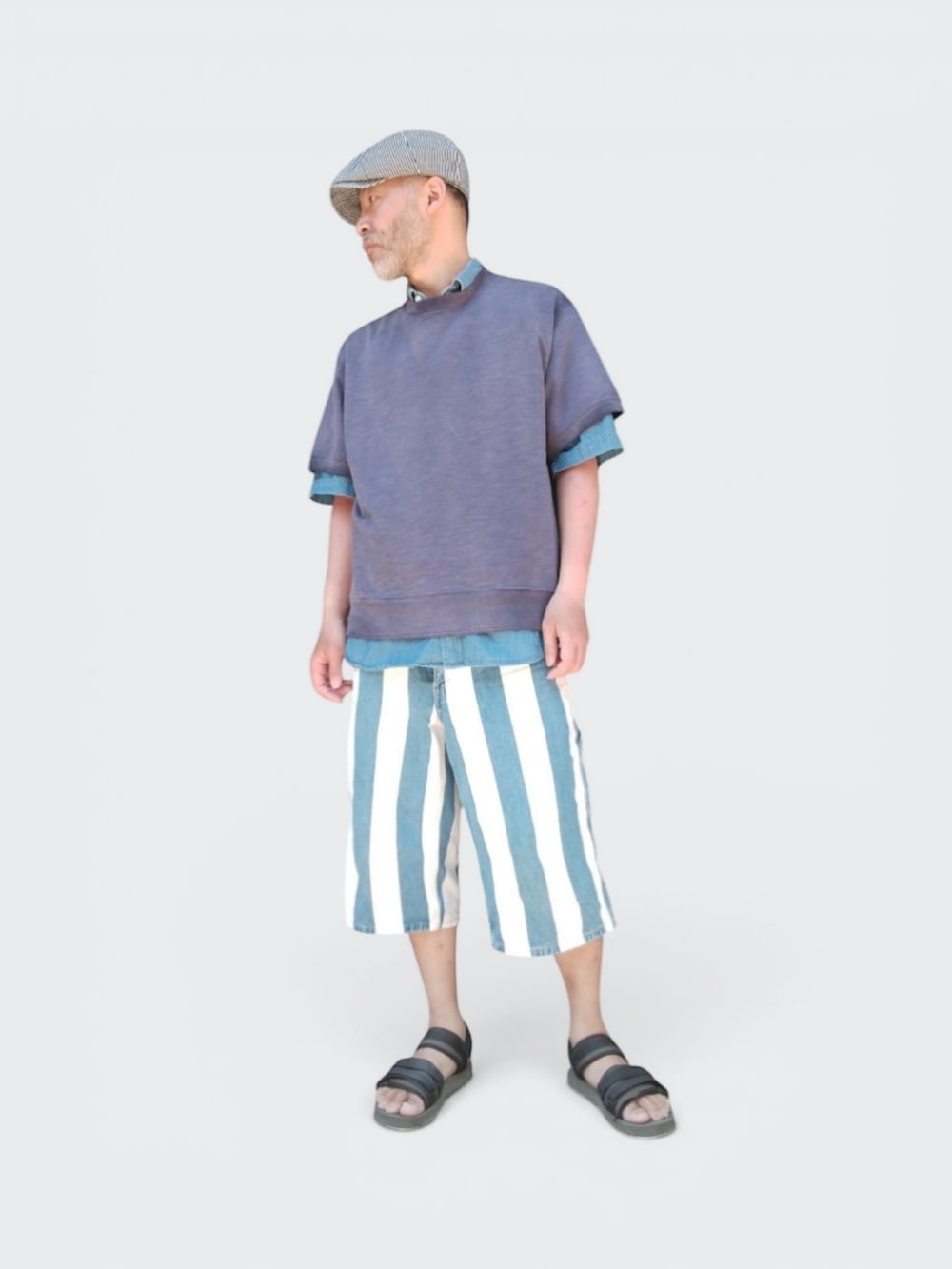 グリーン系のサンダル、ブルー系のパンツ、パープル系のTシャツ/カットソーを着用したメンズの春コーディネートの4枚目の写真