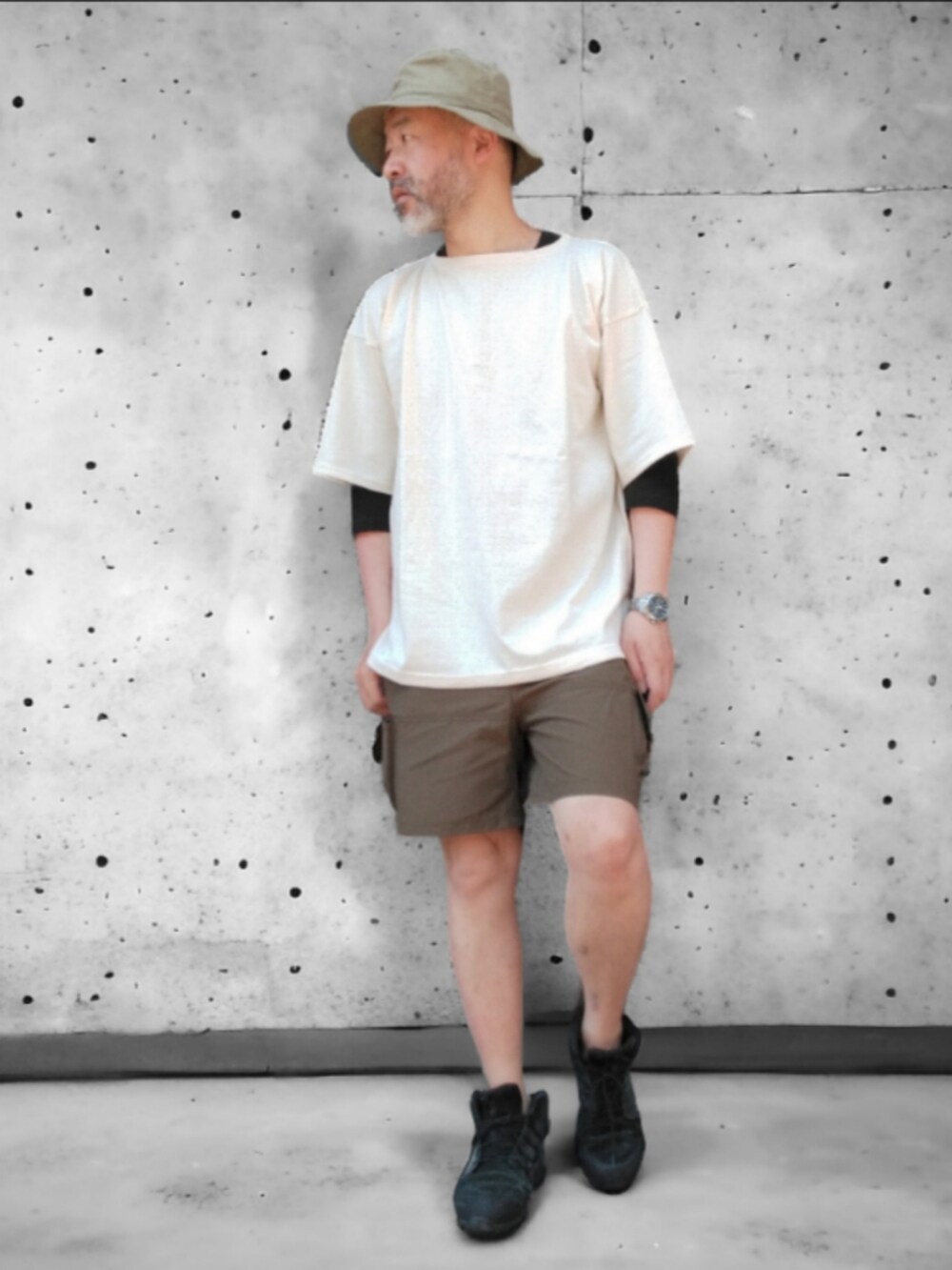 グリーン系のパンツ、ホワイト系のTシャツ/カットソー、グリーン系のハットを着用したメンズの春コーディネートの3枚目の写真