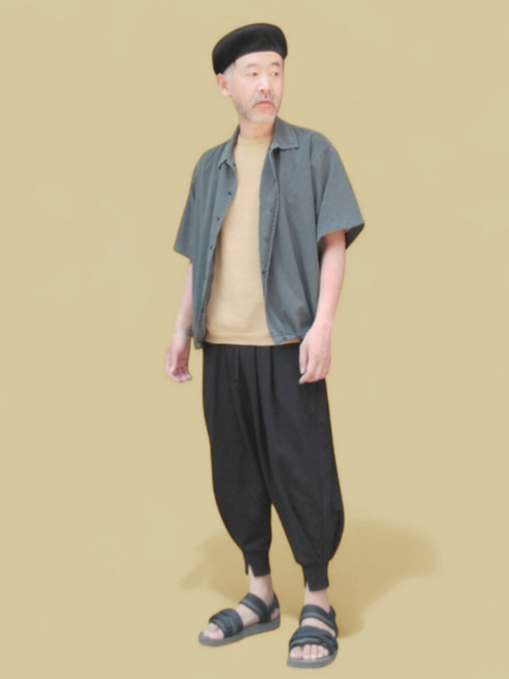 グレー系のパンツ、グリーン系のサンダル、イエロー系のニット/セーターを着用したメンズの春コーディネートの4枚目の写真