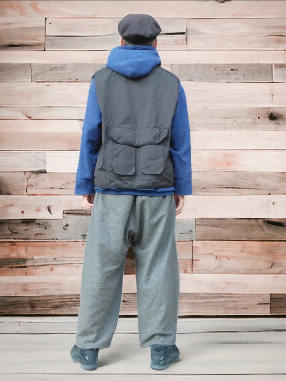 ブラック系のスニーカー、グレー系のパンツ、ブラック系のベストを着用したメンズの秋コーディネートの5枚目の写真