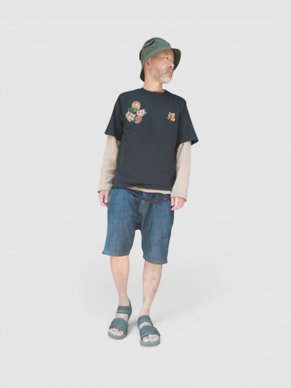 ブルー系のデニムパンツ、ブラック系のサンダル、ブラック系のTシャツ/カットソーを着用したメンズの夏コーディネートの4枚目の写真