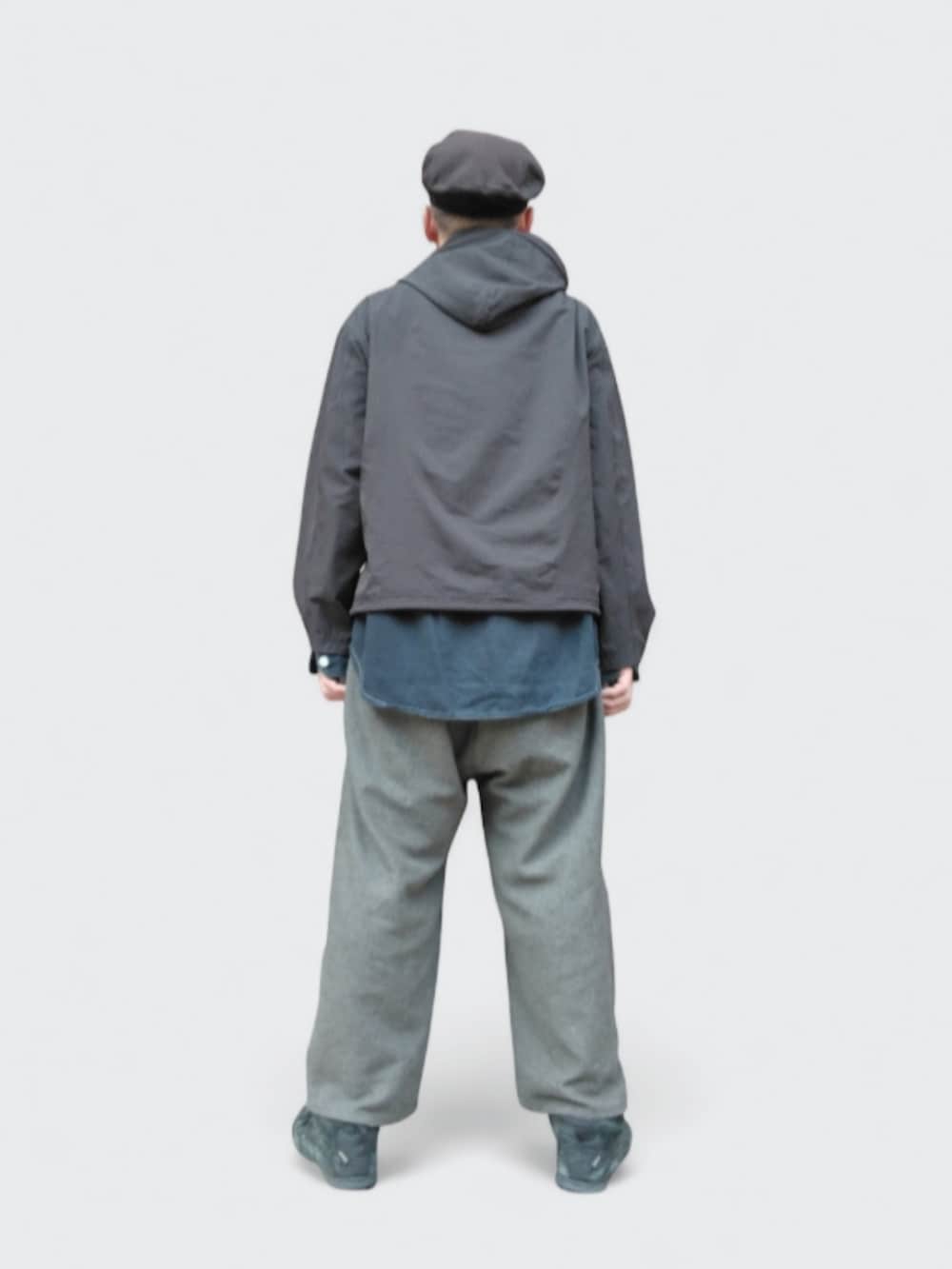 グレー系のパンツ、ブラック系のパーカー、ブラック系のハンチング/ベレー帽を着用したメンズの冬コーディネートの5枚目の写真