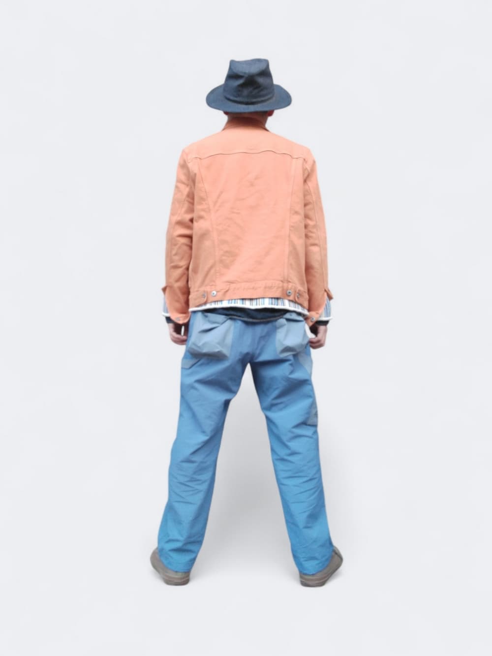 ブルー系のパンツ、オレンジ系のデニムジャケット、ブルー系のハットを着用したメンズの春コーディネートの5枚目の写真