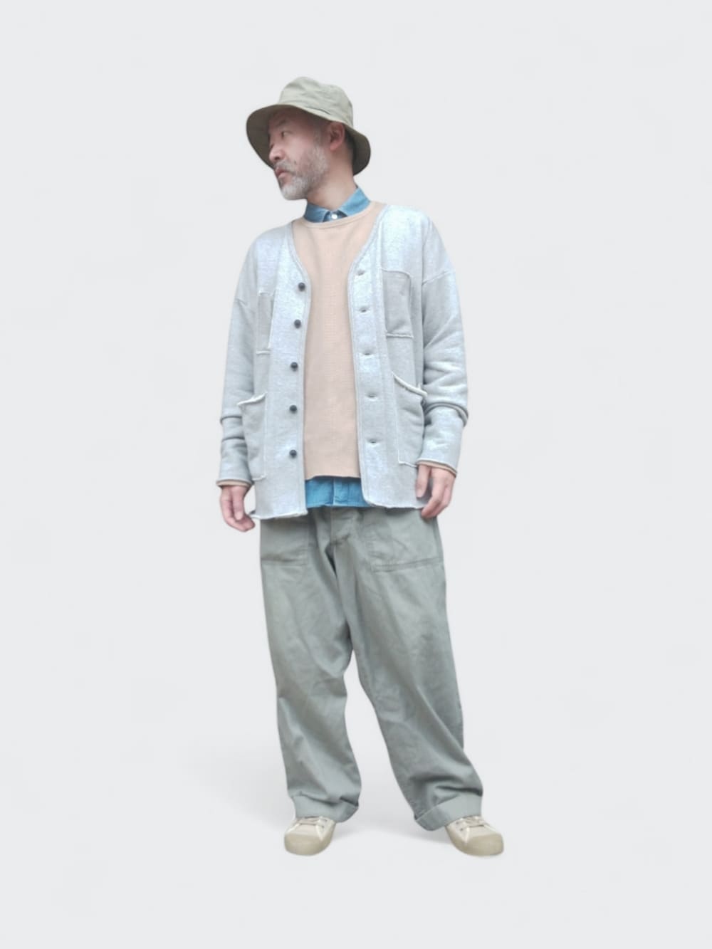 グリーン系のカーゴパンツ、グレー系のカーディガン/ボレロ、ベージュ系のスウェットを着用したメンズの春コーディネートの3枚目の写真