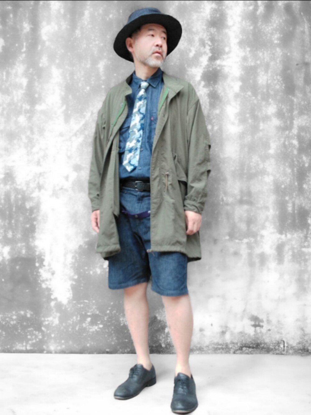 グリーン系のモッズコート、ブルー系のデニムパンツ、ブルー系のハットを着用したメンズの春コーディネートの2枚目の写真