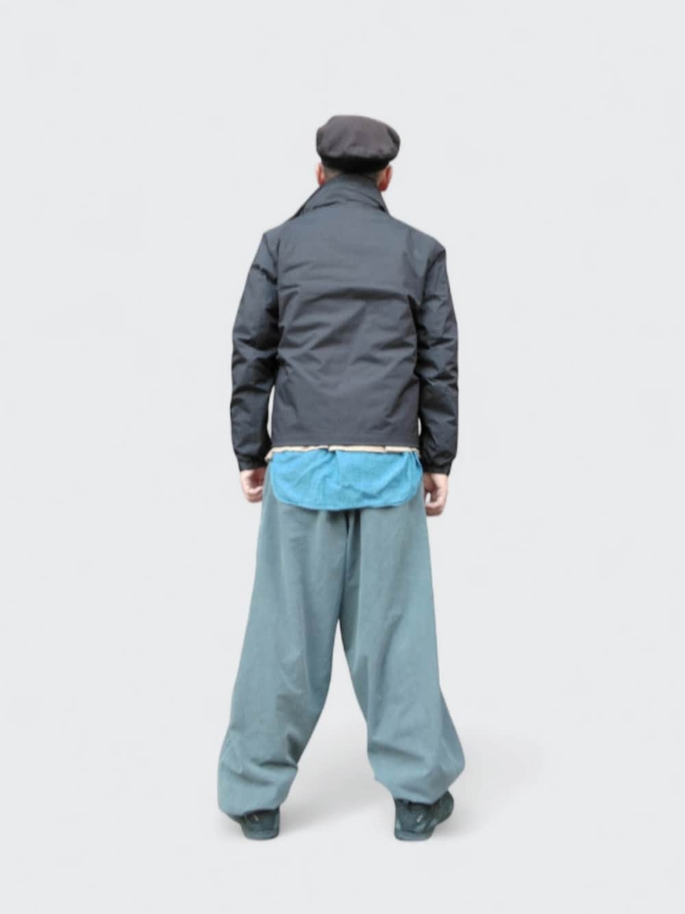 グレー系のパンツ、ブラック系のダウンジャケット/コート、ブラック系のスニーカーを着用したメンズの冬コーディネートの5枚目の写真