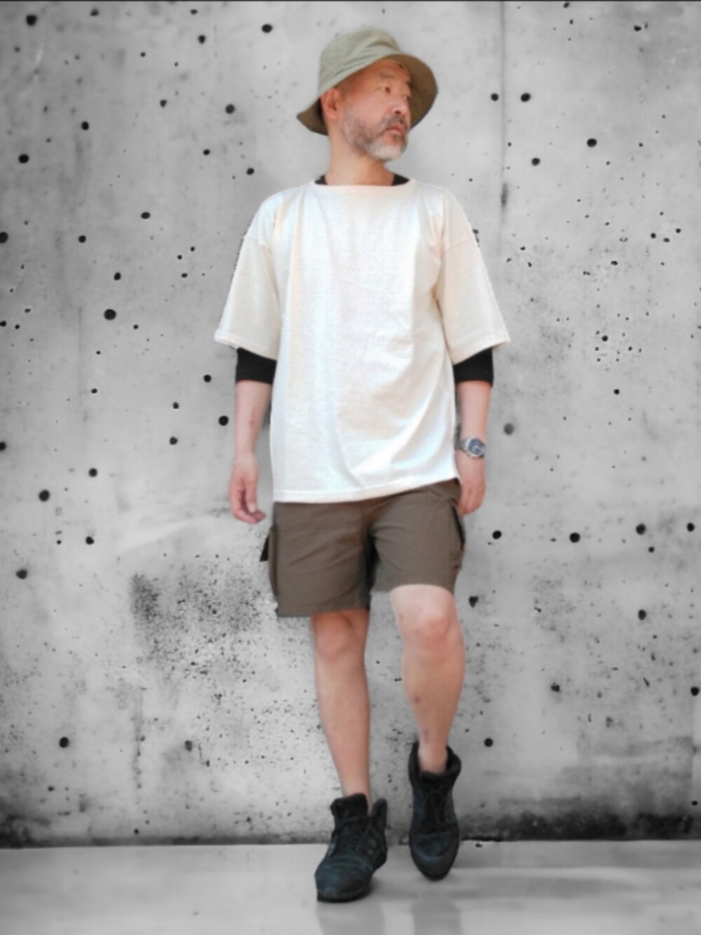 グリーン系のパンツ、ホワイト系のTシャツ/カットソー、グリーン系のハットを着用したメンズの春コーディネートの2枚目の写真