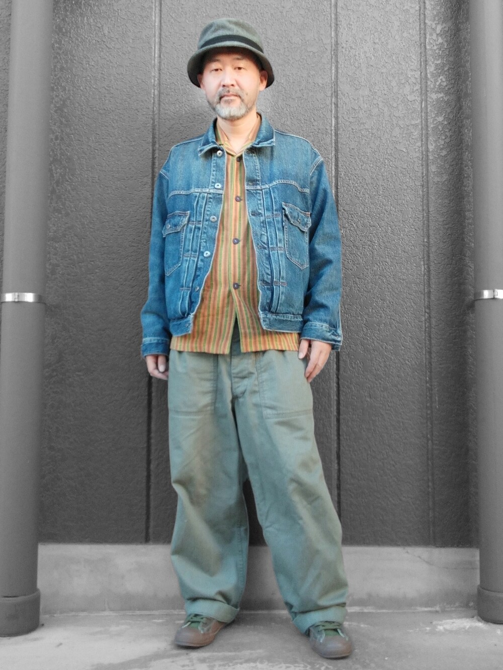 グリーン系のカーゴパンツ、ブラック系のスニーカー、ブルー系のデニムジャケットを着用したメンズの冬コーディネートの3枚目の写真