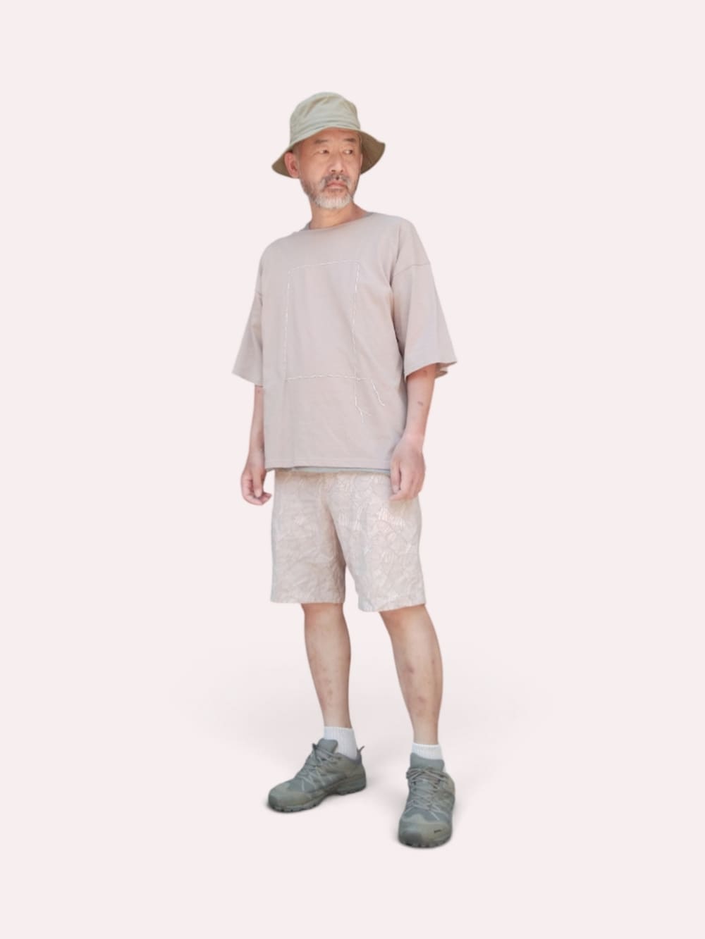 ベージュ系のその他パンツ、グリーン系のスニーカー、ベージュ系のTシャツ/カットソーを着用したメンズの夏コーディネートの2枚目の写真
