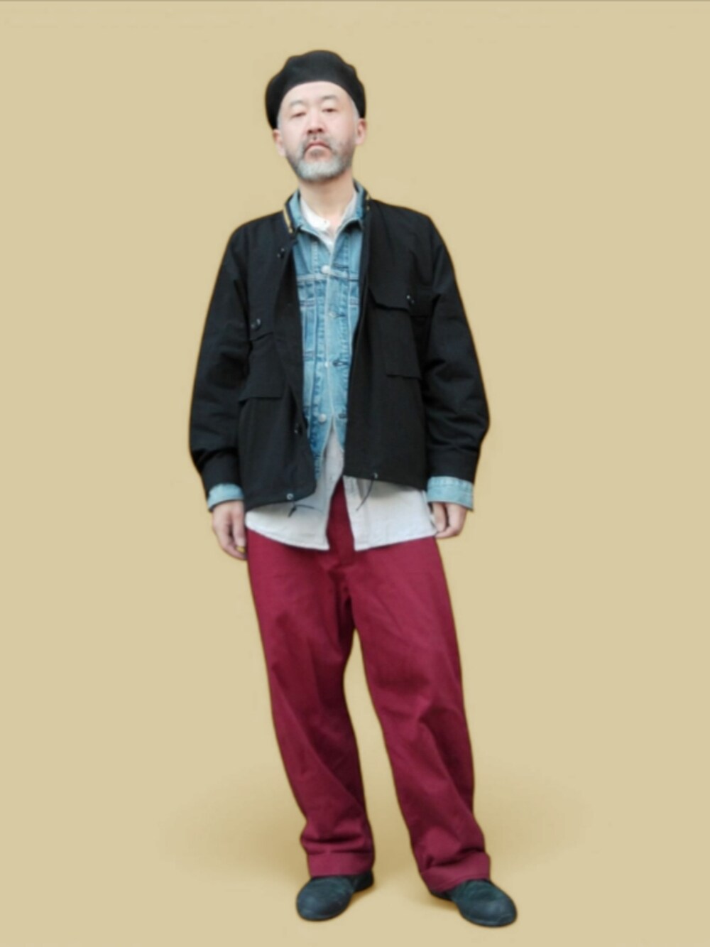 ブラック系のスニーカー、レッド系のチノパンツ、ブルー系のデニムジャケットを着用したメンズの春コーディネートの3枚目の写真