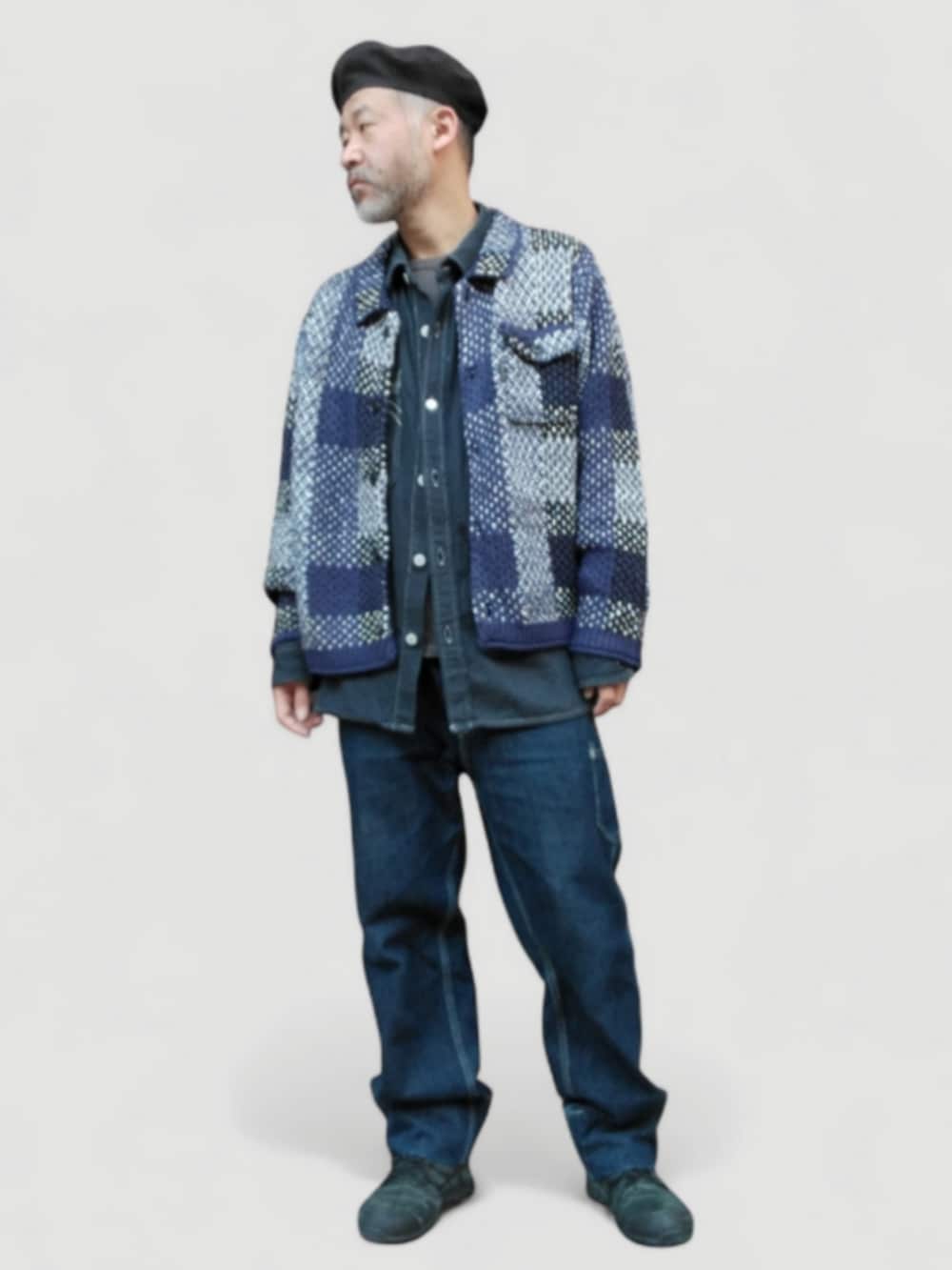 ブラック系のスニーカー、ブルー系のデニムパンツ、ブルー系のニット/セーターを着用したメンズの冬コーディネートの3枚目の写真