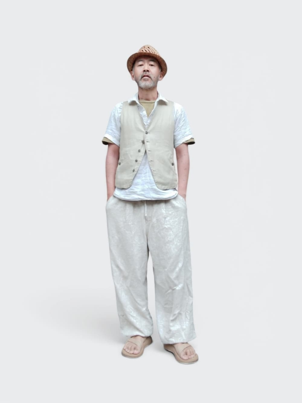 ベージュ系のサンダル、ホワイト系のパンツ、ベージュ系のハットを着用したメンズの夏コーディネートの3枚目の写真