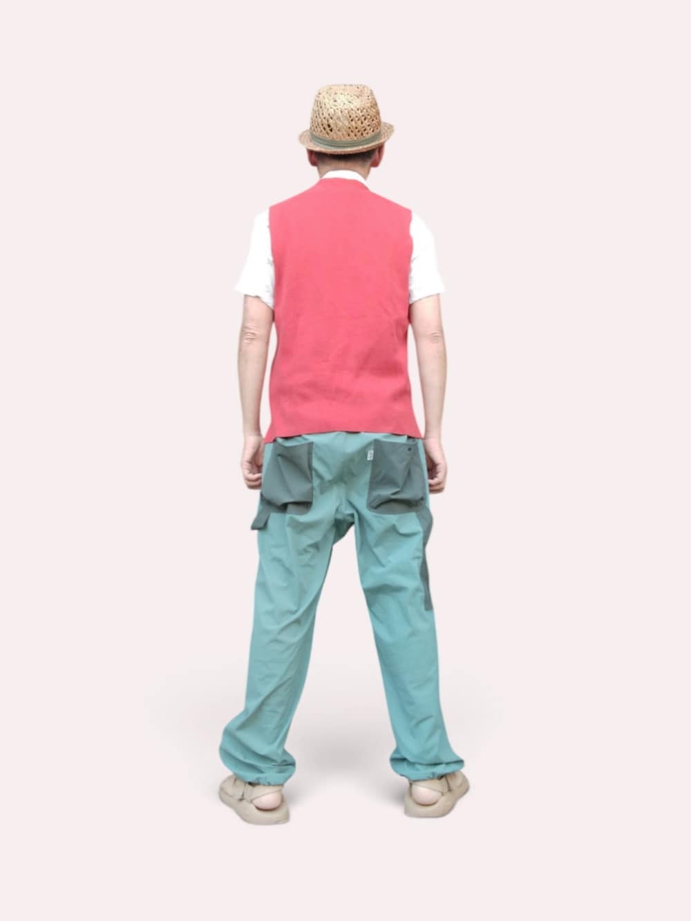 グリーン系のパンツ、ベージュ系のサンダル、レッド系のベストを着用したメンズの夏コーディネートの5枚目の写真