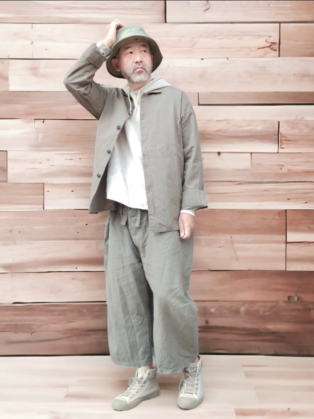 グリーン系のその他パンツ、ベージュ系のスニーカー、ベージュ系のパーカーを着用したメンズの秋コーディネートの2枚目の写真