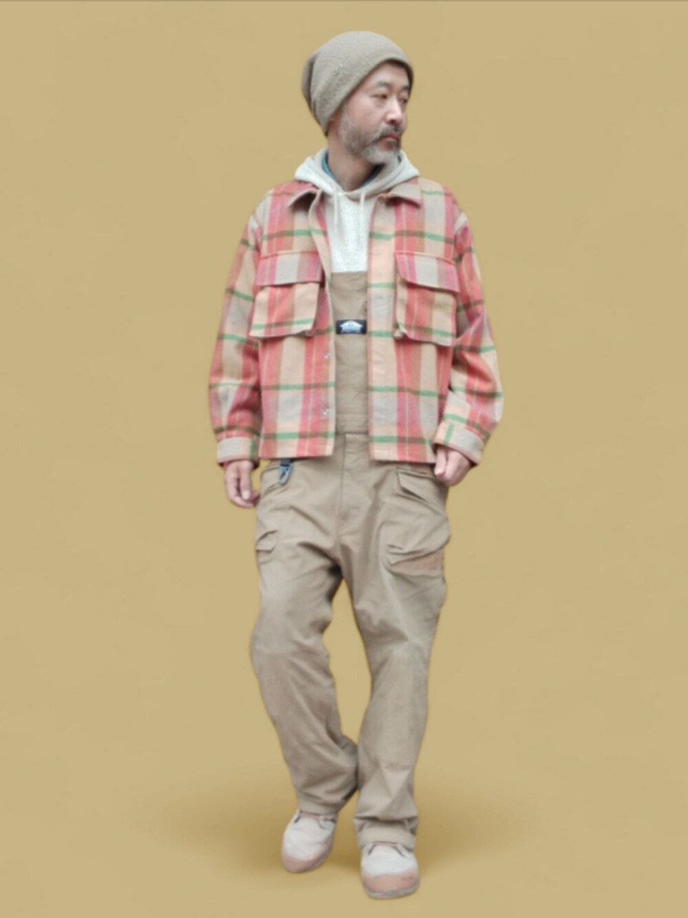 ベージュ系のサロペット/オーバーオール、ベージュ系のスニーカー、ベージュ系のパーカーを着用したメンズの秋コーディネートの4枚目の写真