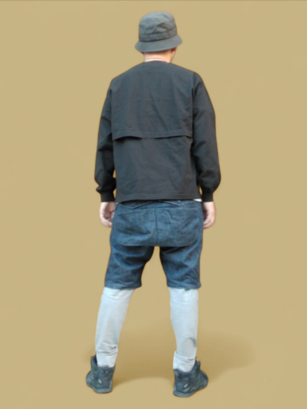 ブルー系のデニムパンツ、ブラック系のスニーカー、ブラック系のハットを着用したメンズの秋コーディネートの5枚目の写真