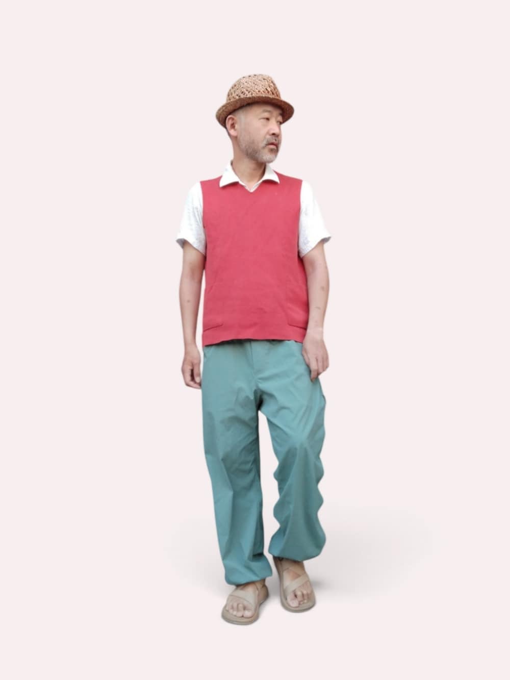 グリーン系のパンツ、ベージュ系のサンダル、レッド系のベストを着用したメンズの夏コーディネートの4枚目の写真
