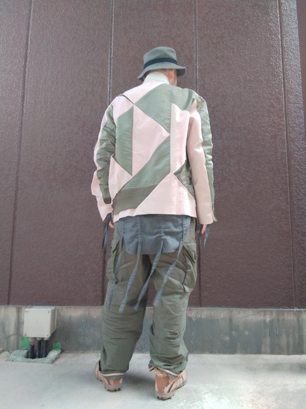 ベージュ系のスニーカー、グリーン系のカーゴパンツ、ピンク系のジャケット/アウターを着用したメンズの春コーディネートの3枚目の写真