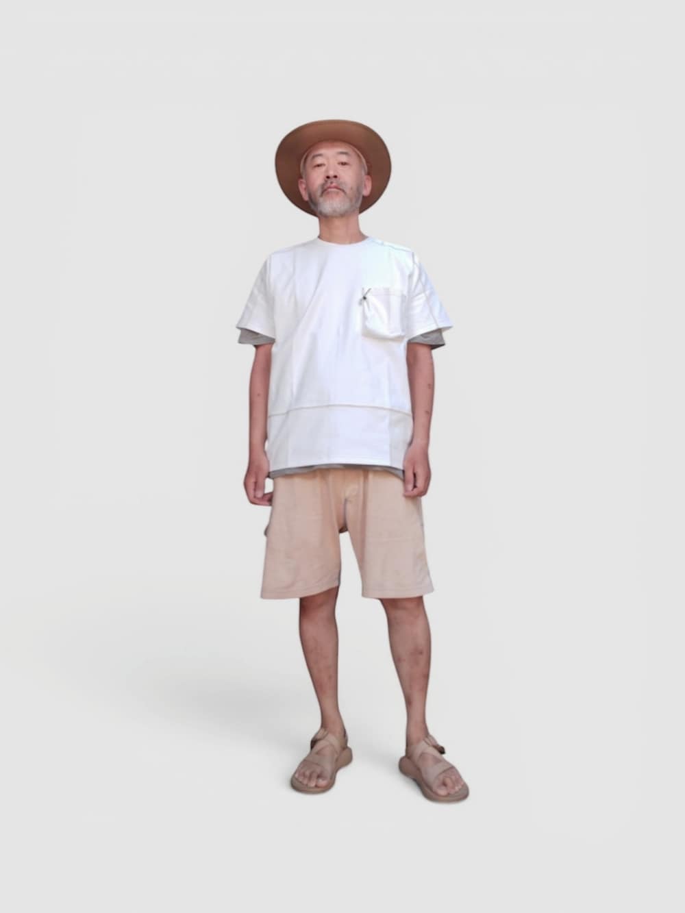 イエロー系のパンツ、ベージュ系のサンダル、ホワイト系のTシャツ/カットソーを着用したメンズの夏コーディネートの2枚目の写真
