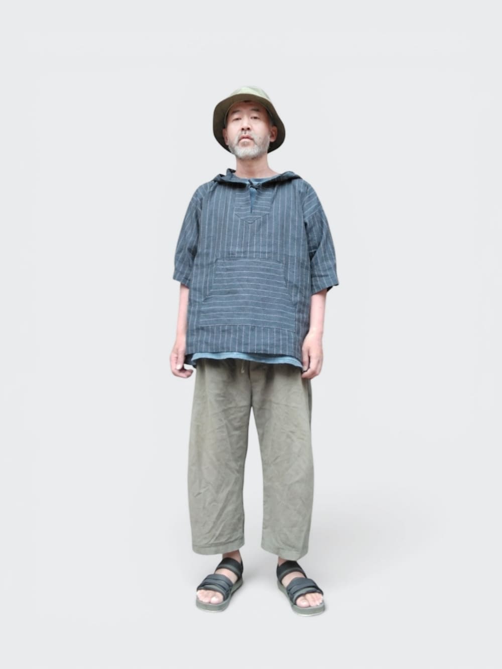 グリーン系のその他パンツ、グリーン系のサンダル、ブルー系のパーカーを着用したメンズの夏コーディネートの3枚目の写真