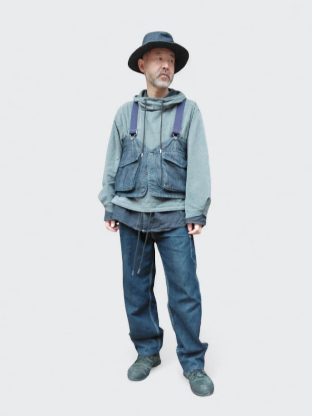 ブルー系のデニムパンツ、ブラック系のスニーカー、ブルー系のベストを着用したメンズの冬コーディネートの4枚目の写真