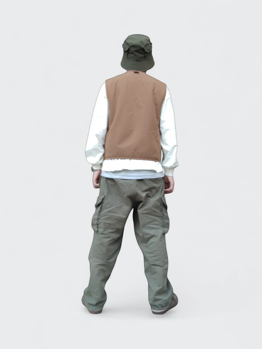 グリーン系のカーゴパンツ、グリーン系のスニーカー、ブラウン系のベストを着用したメンズの冬コーディネートの4枚目の写真