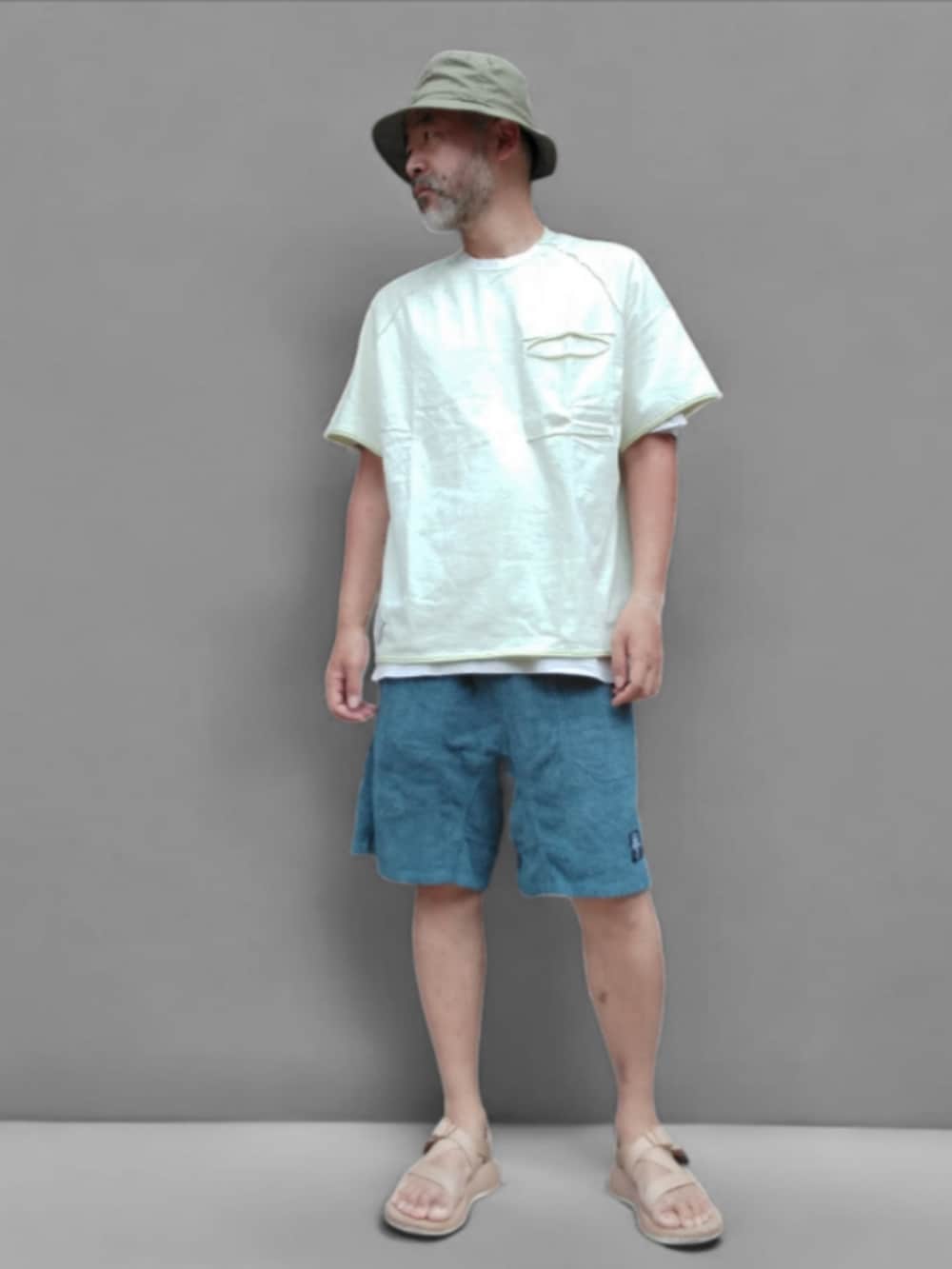 ホワイト系のTシャツ/カットソー、ブルー系のパンツ、ベージュ系のサンダルを着用したメンズの夏コーディネートの3枚目の写真
