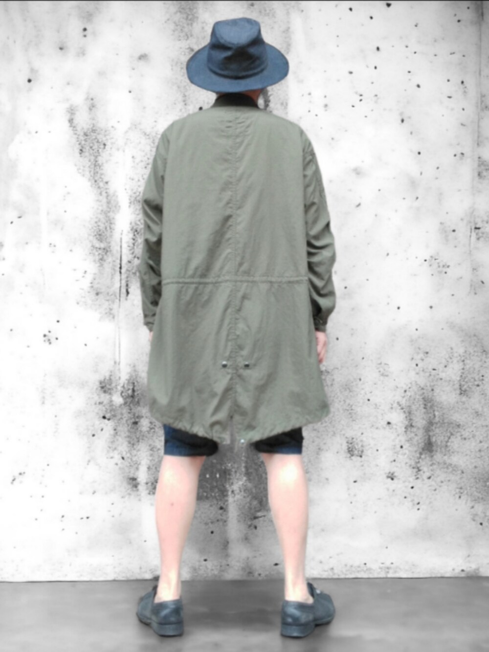 グリーン系のモッズコート、ブルー系のデニムパンツ、ブルー系のハットを着用したメンズの春コーディネートの5枚目の写真